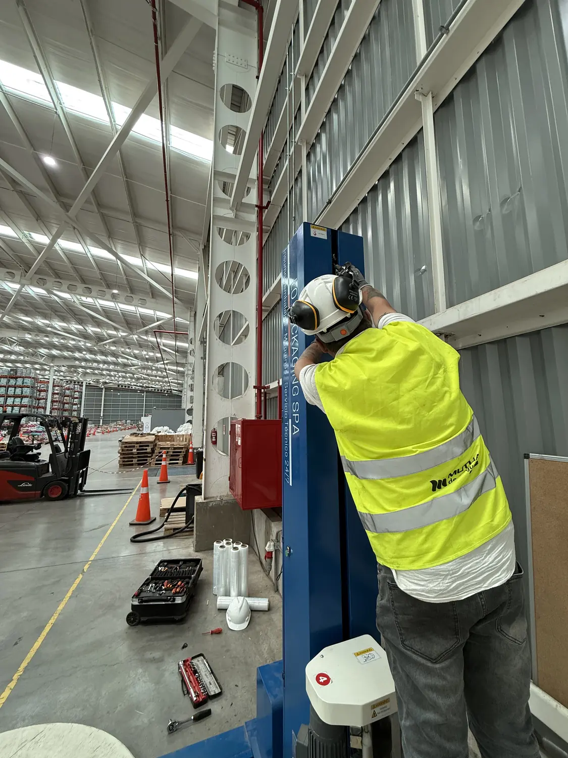 Técnico montando la columna de una envolvedora en planta